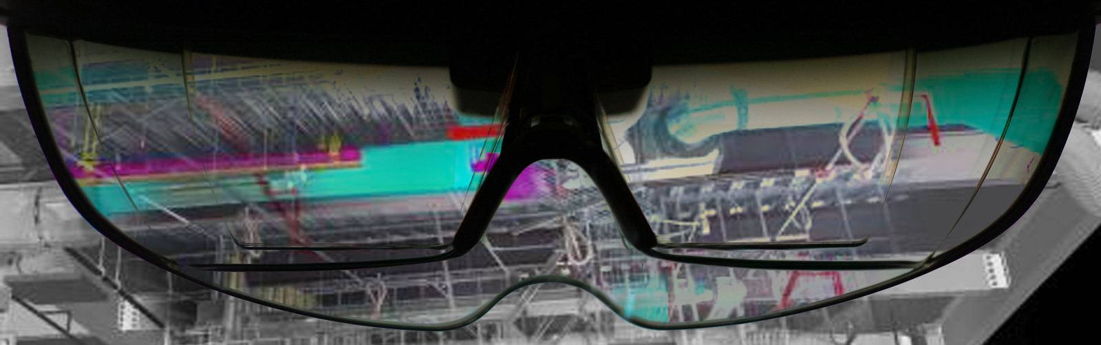 Närbild på ett par HoloLens-glas där en modell i magenta, cyan och grönt syns i glasen mot en gråskalig bakgrund.